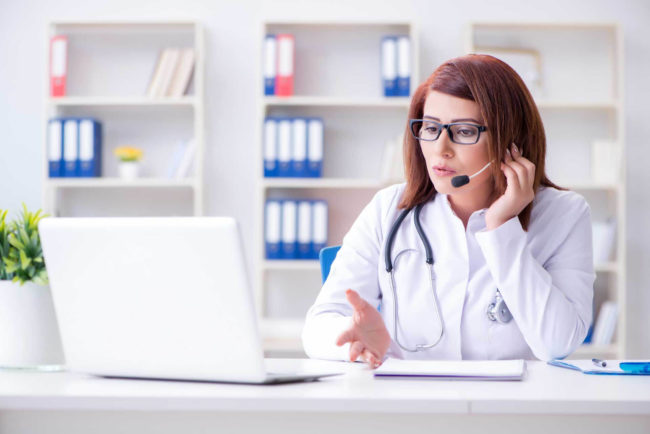 telemedicine woman doctor speaking to breast cancer patient over video call